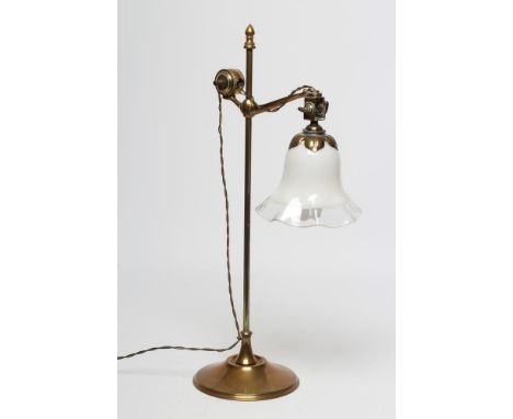 A BRASS DESK LAMP, the plain turned stem issuing an adjustable branch hanging an opaque glass shade with clear glass frilled 