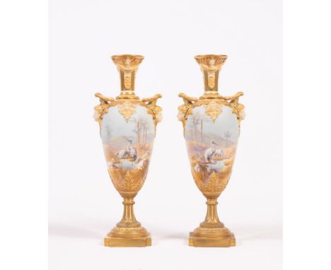 A PAIR OF ROYAL WORCESTER CHINA VASES, 1912, of slender ovoid form, with swag moulded high neck, the wreath handles with mask