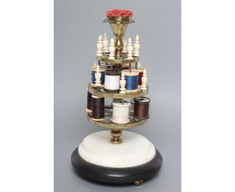 A VICTORIAN BRASS BOBBIN STAND comprising three graduated pierced trays with turned bone finials on baluster turned stem with