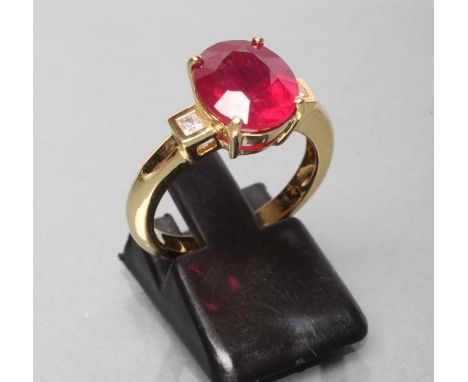 A RUBY RING, the oval facet cut stone of approximately 5.1cts, claw set to square shoulders each with a small princess cut di