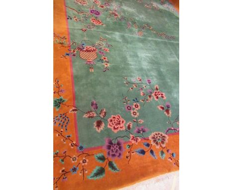 A LARGE CHINESE WASHED AND FRINGED CARPET, early 20th century, the jade green centre with cinnamon border and soft pink guard