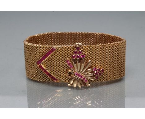 A COCKTAIL BRACELET, the mesh woven 1" wide strap with open oblong clasp panel surmounted by a hinged stylised flower spray o