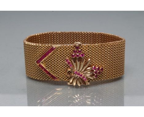 A COCKTAIL BRACELET, the mesh woven 1" wide strap with open oblong clasp panel surmounted by a hinged stylised flower spray o