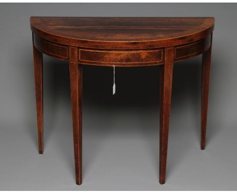 A GEORGIAN ROSEWOOD FOLDING CARD TABLE, c.1800, of demi lune form with stringing, the banded top opening to reveal a green ba