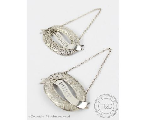 A pair of Anglo-Indian decanter labels, titled 'port' and 'sherry' on a banner within a coiled wirework surround, 6.5cm wide 
