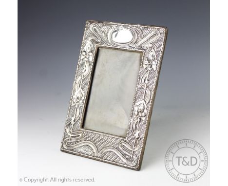 A silver mounted Art Nouveau photograph frame, Chester 1906, the rectangular frame with embossed sinuous floral motifs, vacan