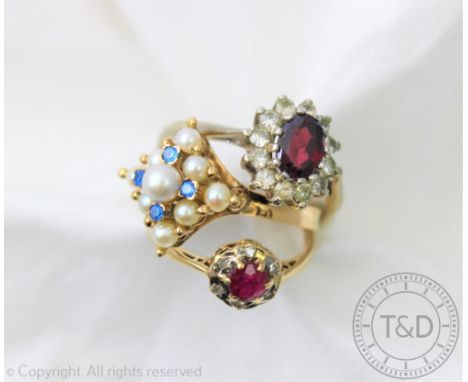 Three rings, to include; a ruby and diamond circular cluster in 9ct gold, a garnet cluster in white metal and an untested pea