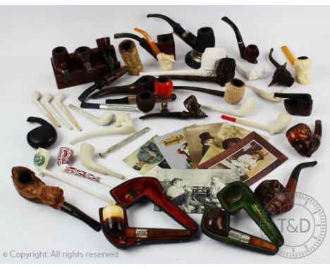 An assorted collection of smoking pipes to include silver mounted examples, clay examples, meerschaum examples, carved wood e