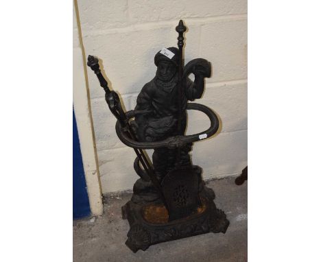 A cast iron stick stand and fire tools