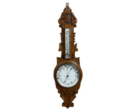 CARVED OAK CIRCULAR DIAL ANEROID WALL BAROMETER - in fine colour and condition and with mercury thermometer above the dial, M