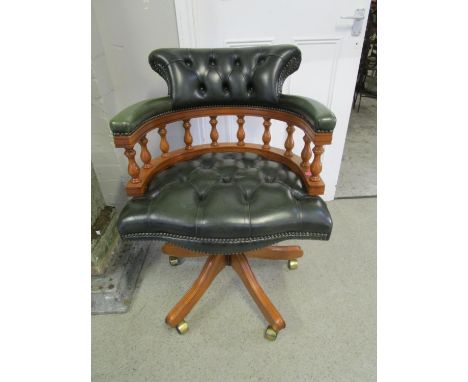 A modern light wood and green button back upholstered swivel office chair 