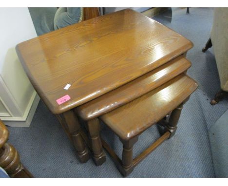 An Ercol elm nest of three tables, the largest 17 1/2"h x 24 1/4"w 