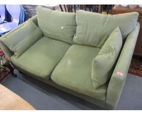 A modern green upholstered two seater sofa 