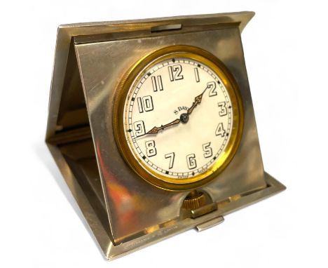A silver engine turned 8-day travel clock, by Cohen & Charles, London, 1927, the white enamel dial with arabic numerals and i