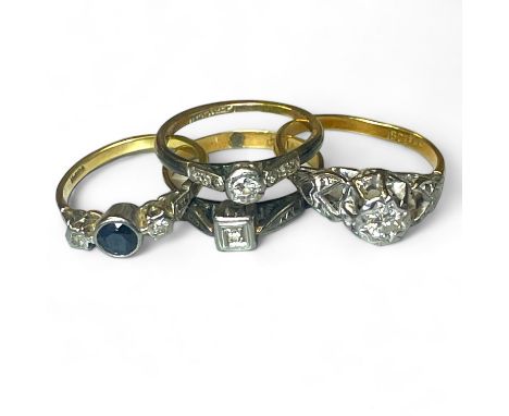 A group of four early 20th century diamond set rings.  Comprising a raised illusion set diamond solitaire ring, stamped "18ct
