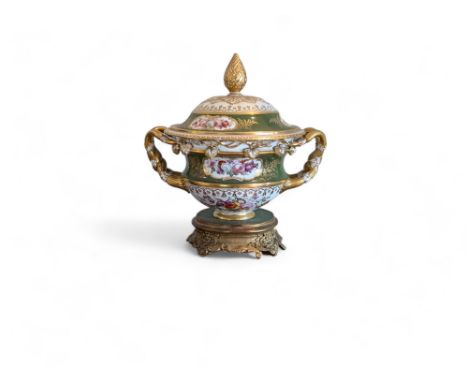 A 19th Century porcelain floral decorated twin handled lidded centrepiece on an associated gilt wood base. 33cm by 27cm by 35