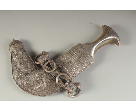 A FINE EARLY 20TH CENTURY ARAB OMANI SILVER MOUNTED JAMBIYA DAGGER, with horn handle.