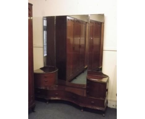 A Colonial mahogany triple mirror dressing table with six carved upper drawers over three drawers and side cupboards, on carv