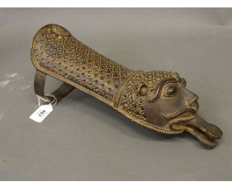 A Persian pierced bronze arm guard with stylised lion mask head, 13" long 