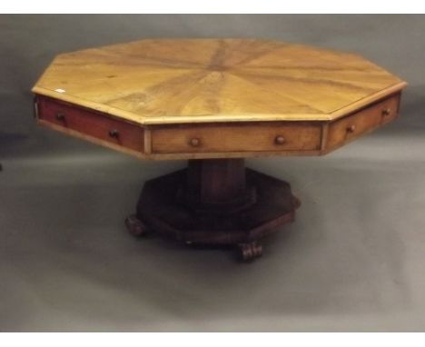 A C19th mahogany revolving octagonal topped table with four true and four false drawers, the top with sectional figured venee