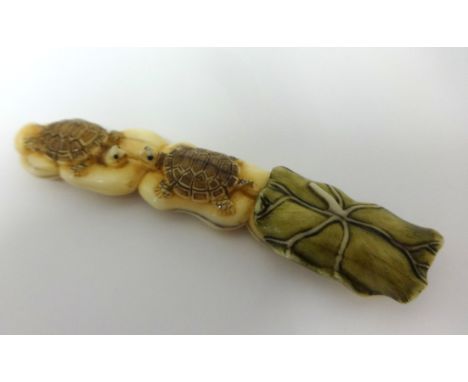 A large netsuke carved in the form of two tortoise on a lotus.