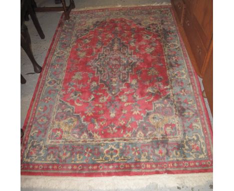 Persian design carpet on a red ground with foliate decoration.