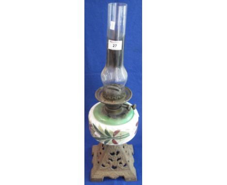 Early 20th Century brass double burner oil lamp having painted ceramic reservoir and pierced cast metal base with clear chimn