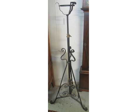Wrought iron scroll decorated oil burner tripod standard lamp.