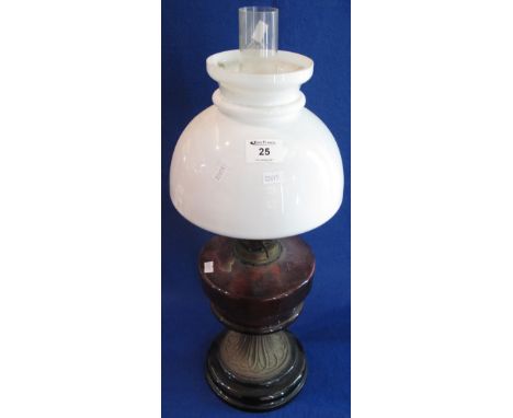 Early 20th Century brass double burner oil lamp, having ruby glass reservoir, fluted metal base on ceramic foot with white gl