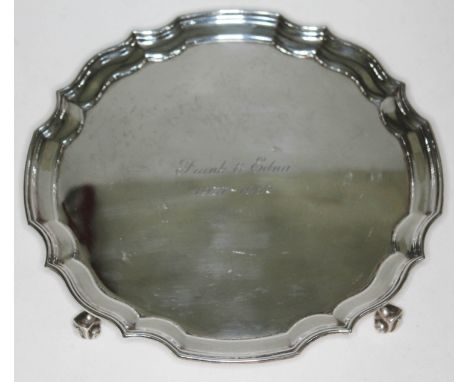 A silver salver with scallop edge and stood on four scroll feet, J.D. Chatterly and Sons, Birmingham 1961, diam. 20.5cm, wt. 