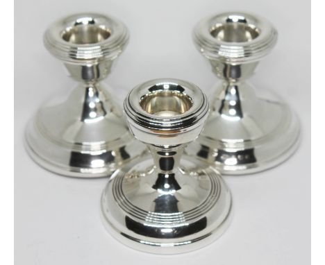 A set of three hallmarked silver candlesticks, height 6.5cm.  