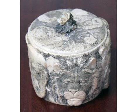 A Japanese Meiji period carve ivory tusk section lidded jar carved all over with elephants, tigers, lions and apes and with m