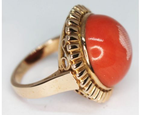 A Polish ring set with a large coral cabochon, Polish 14ct gold marks, Wrochaw essay mark, gross wt. 10.83, size M.  