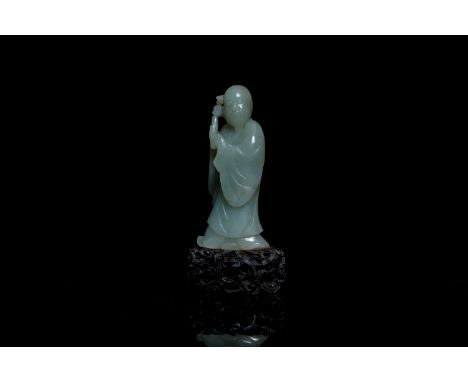 Full title:  A Chinese carved celadon jade 'immortal' figure on wooden stand, QingDescription: H.: 13 cm (incl. stand)H.: 10,