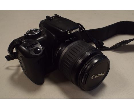 A Canon EOS 400D camera with strap and EF-S 18-55mm zoom lens, with accessories to include camera bag, filters, polarizer, ba