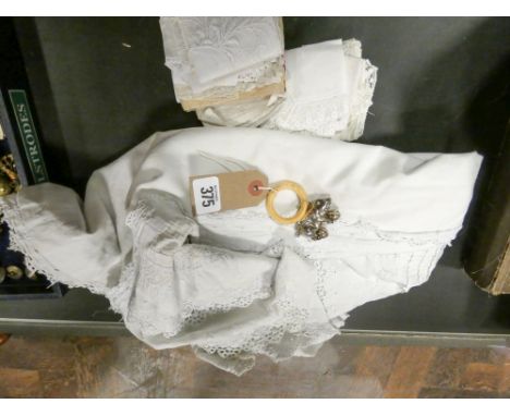 A vintage christening gown and a silver pig teething ring 