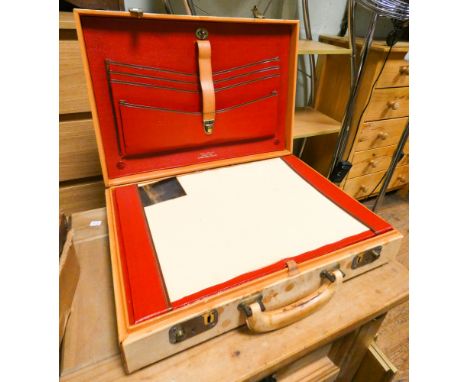A vintage coach hide brief case with red leather interior 