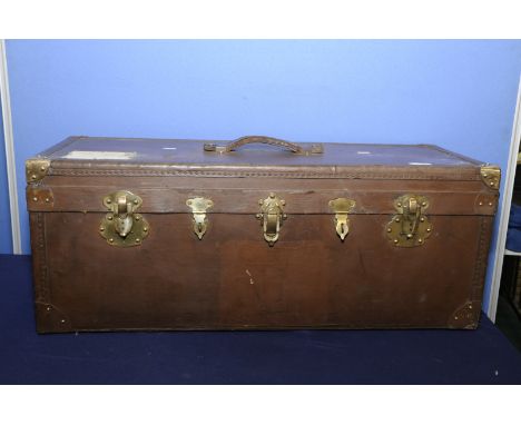 Vintage leather and brass bound canvas travel trunk with central leather strap handle and five locking points, the interior w