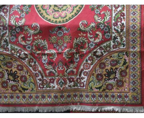 Eastern full pile carpet, centrally decorated with a mustard medallion with scrolled foliage upon a red ground, 280 x 200cm