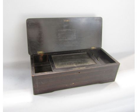 Early 20th century rosewood and ebonised music box, the hinged lid inlaid with a floral spray, containing a cylinder and comb