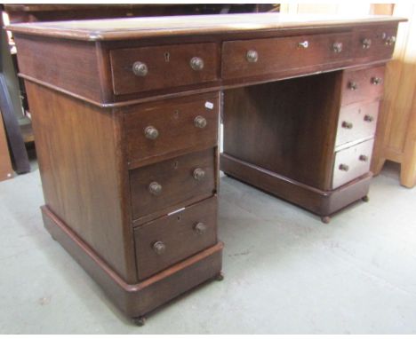 A late 19th century oak pedestal writing desk of nine drawers with inset leather top, 120 cm wide