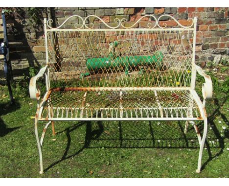 A decorative weathered contemporary light steel two seat garden bench with open scrolled arms and lattice seat and back with 