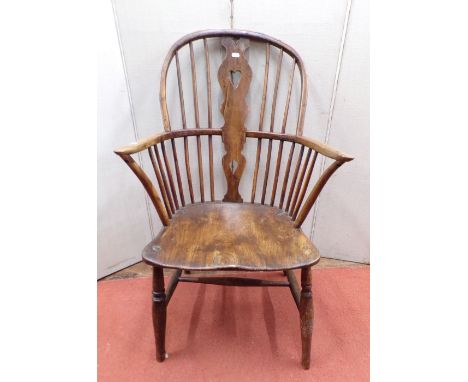 A Georgian comb back elbow chair in mixed woods including elm, yew wood and fruitwood, with turned supports and rails