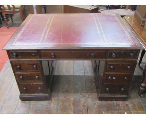 A Victorian mahogany partners desk, each side fitted with nine frieze drawers, the panelled framework beneath a red leather t