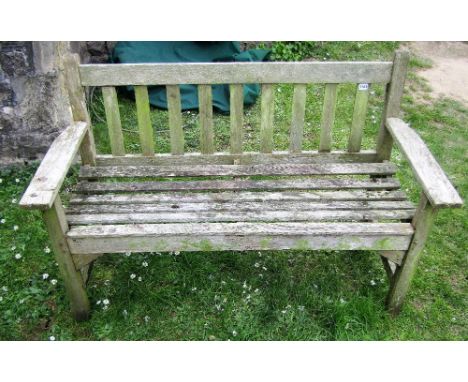 A weathered teak two seat garden bench with slatted seat and back, 128 cm long 