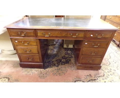 A late Victorian mahogany pedestal writing desk fitted with nine drawers with brass swan neck handles and inset leather top, 