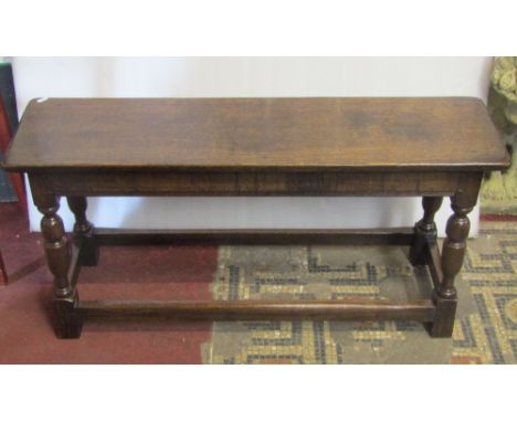 A good quality old English style oak bench in a 17th century manner, raised on four turned supports, 100 cm length