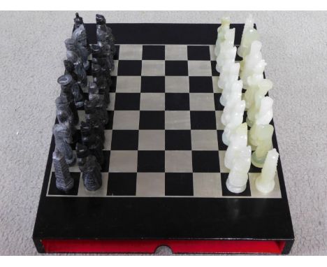A vintage Chinese warrior, imperial emperor and pagoda chess set. One set of pieces is carved white jade and one set is grani