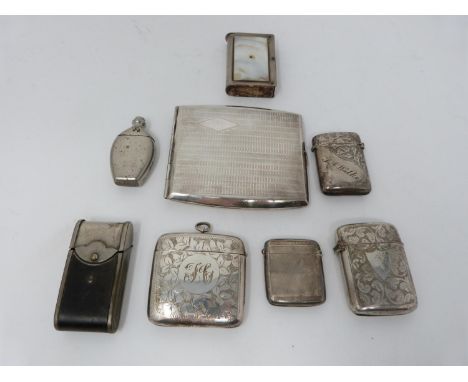 A collection of antique silver and metal vesta cases and a silver cigarette case. Including an engine turned silver cigarette