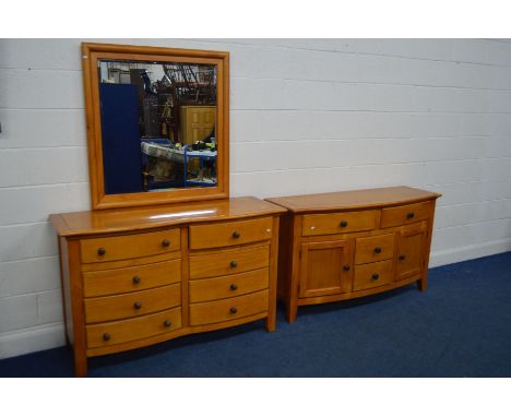 A VARNISHED PINE DRESSING CHEST WITH MIRROR TO TOP, (missing screws)with a double concave front containing eight drawers with